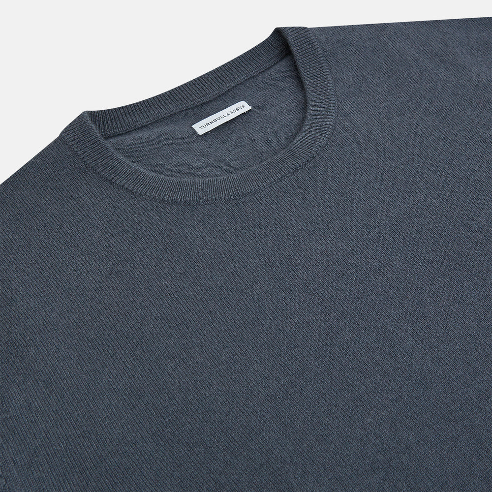 The Turnbull & Asser Grey Cashmere Round Neck Jumper is shown against a light gray background, featuring a relaxed fit with ribbed cuffs, collar, and hem for an elegant look.
