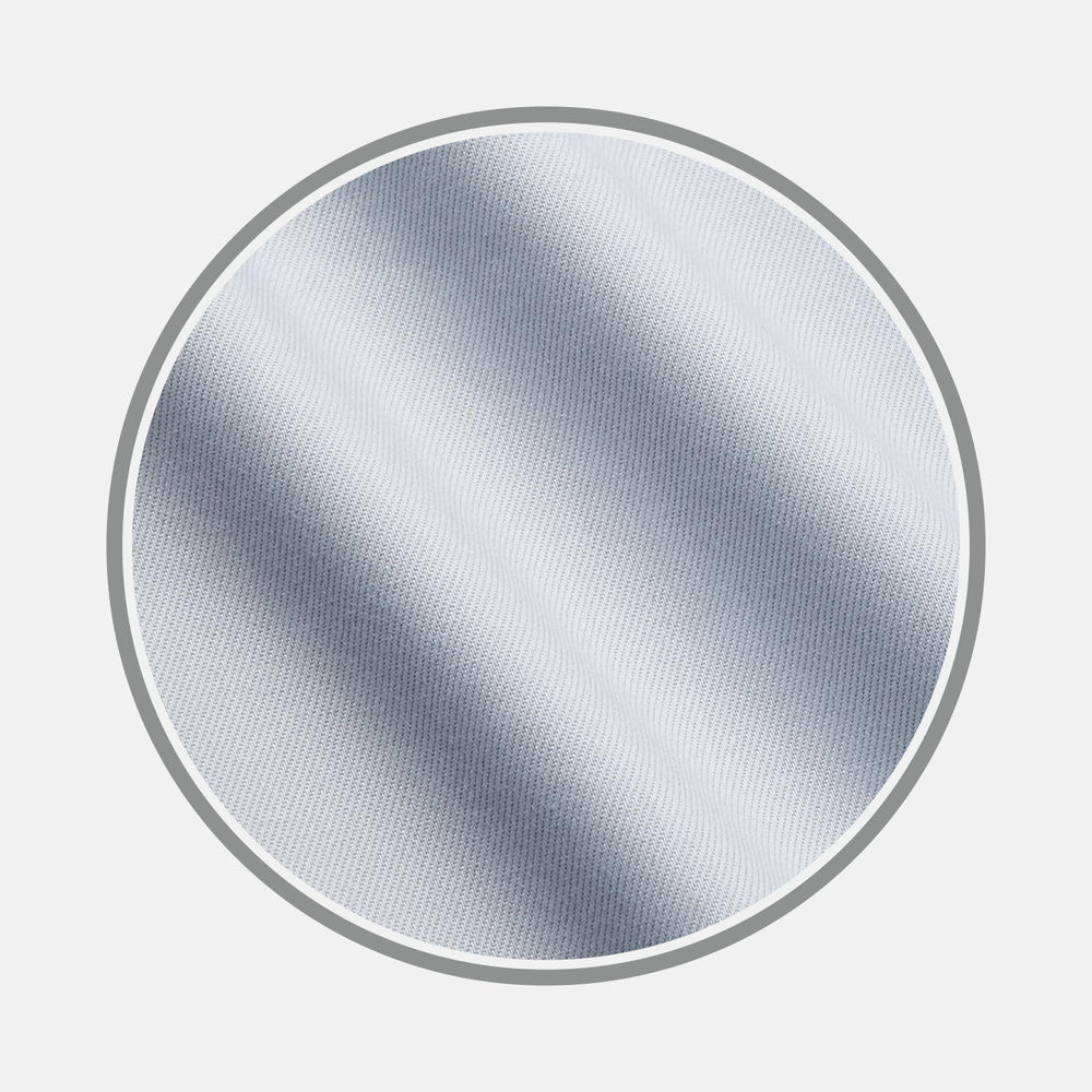 A close-up of BESPOKE FABRIC 1192 04 by Turnbull & Asser, light grey or white with subtle diagonal texture, ideal for custom shirts, displayed in a circular frame on a plain white background.
