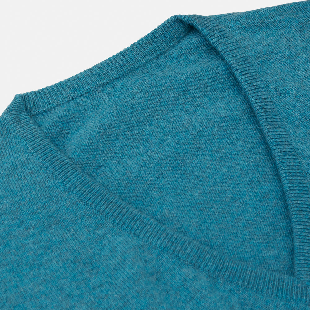 The Teal Paden V-Neck Jumper by Turnbull & Asser is a pure cashmere sweater in teal blue, featuring long sleeves with ribbed cuffs and hem, shown flat on a light gray background.