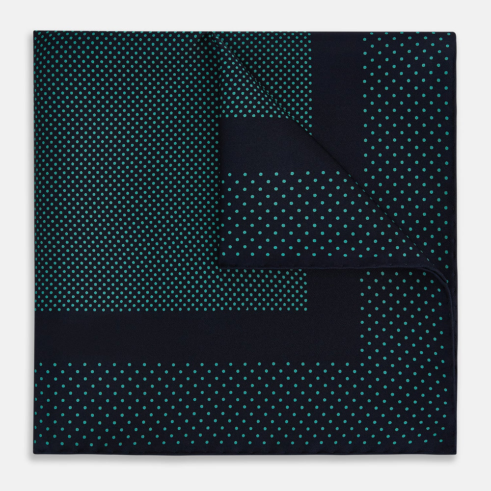 The Turnbull & Asser Navy and Petrol Green Dot Silk Pocket Square features handmade craftsmanship with petrol green polka dots and a darker border, elegantly displayed on a white background.
