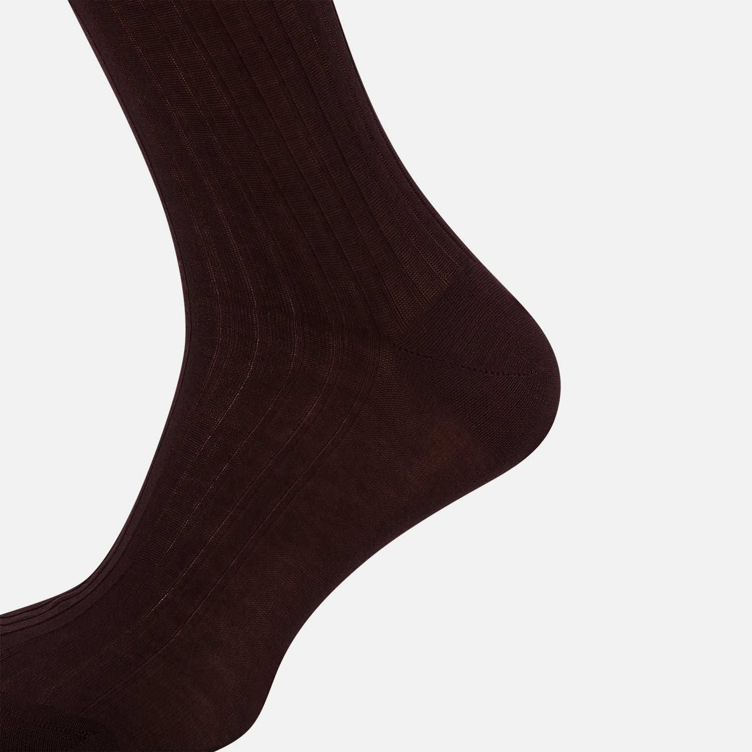 View 4 of product The Turnbull & Asser Oxblood Long Socks—a single, dark brown over-the-calf sock with a ribbed texture—are shown angled left on a plain white background, highlighting their length and fitted shape.