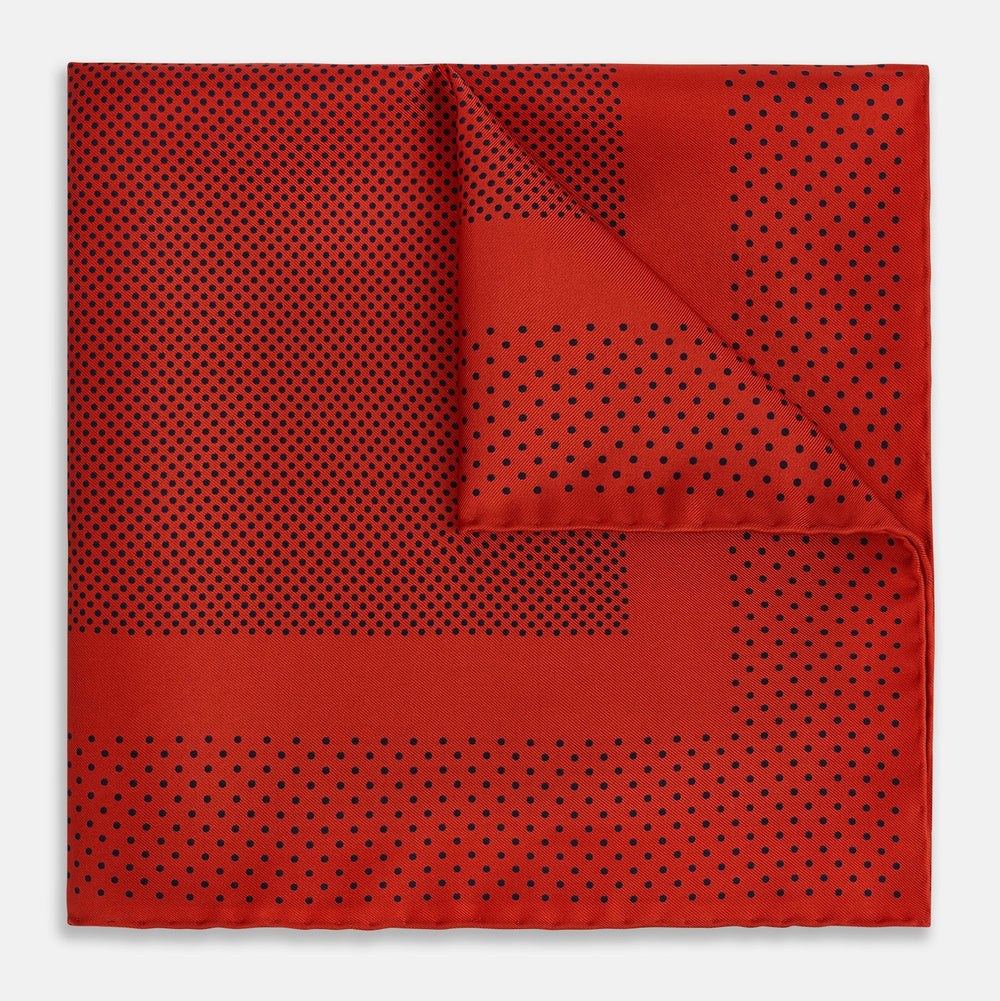 The Turnbull & Asser Red Dot Silk Pocket Square showcases small black dots on red silk, neatly folded to reveal both the front and part of the reverse side.