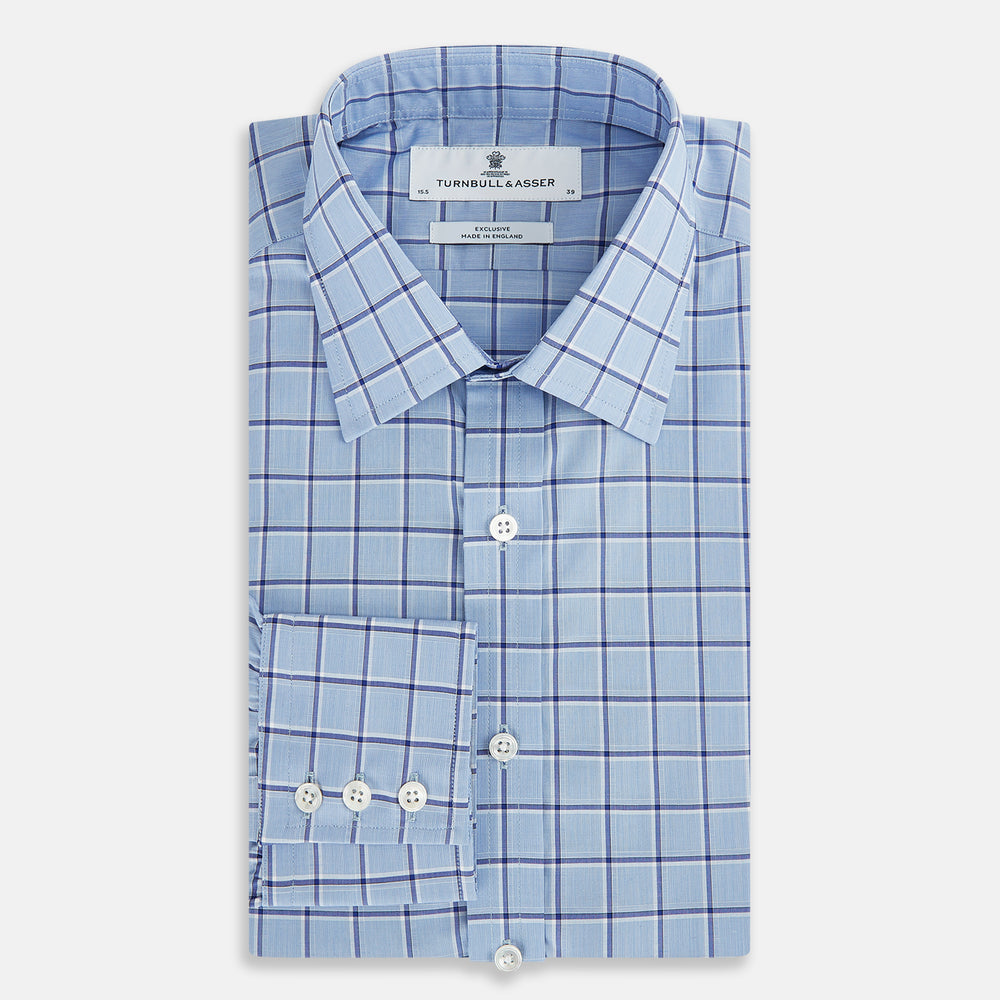The Turnbull & Asser Blue and Navy Windowpane Mayfair Shirt features long sleeves, a T&A collar, buttoned cuffs, and Italian cotton in a blue and navy windowpane pattern, shown on a plain white background.