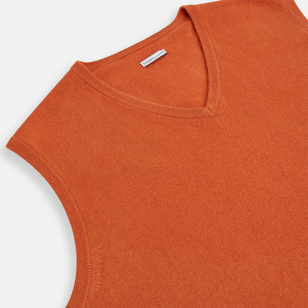 The Turnbull & Asser Orange Cashmere V-Neck Vest adds vibrant style to men’s fashion, featuring a ribbed hem and sleeveless design. Shown against a plain white background.