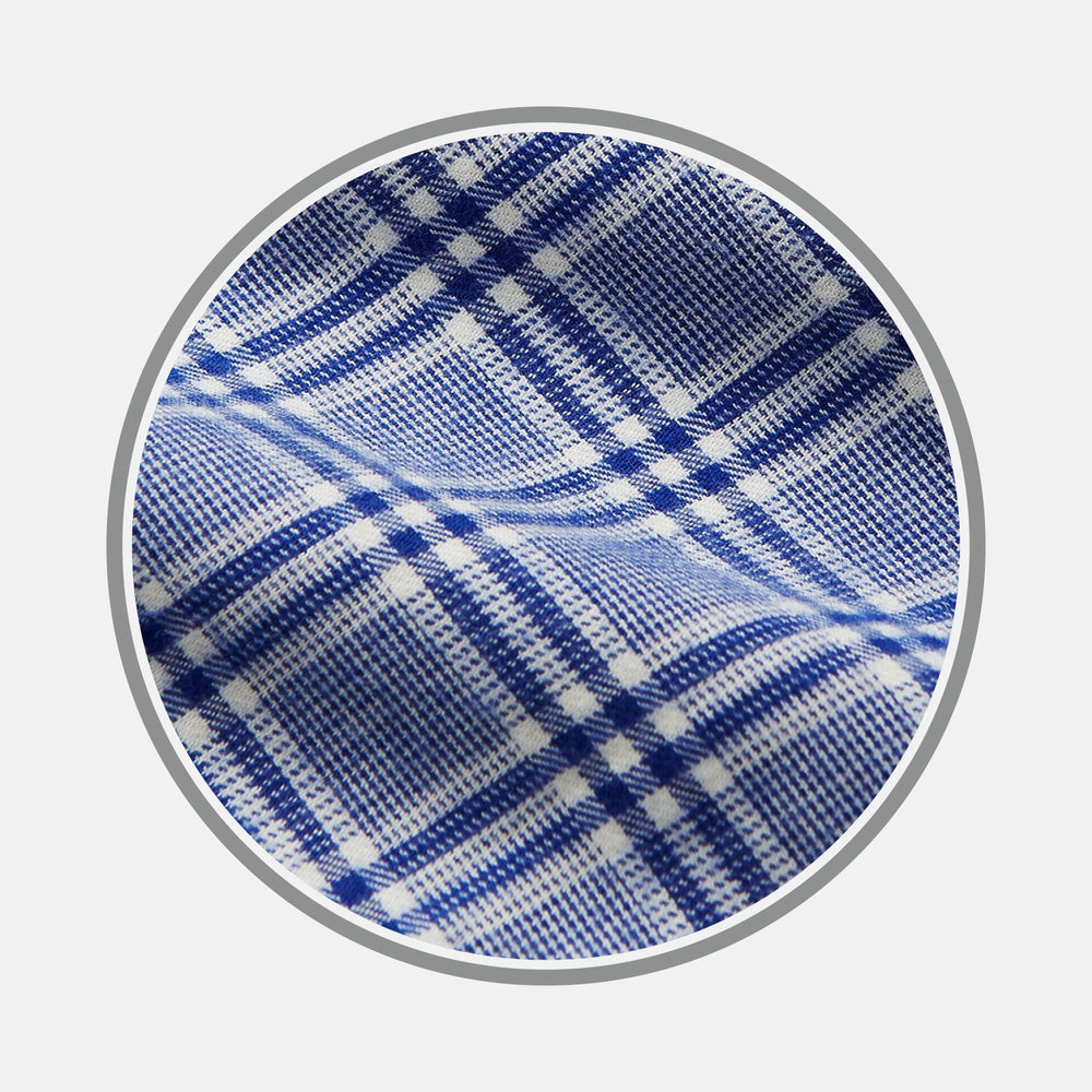 Close-up of BESPOKE FABRIC 1173 06 by Turnbull & Asser—blue and white plaid with diagonal lines and small squares, viewed through a circular frame. Perfect for custom shirt designs that highlight its soft, gently wrinkled texture.