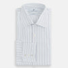 View 5 of product The Turnbull & Asser Blue Wide Pinstripe Mayfair Shirt is a long-sleeved, collared, button-down style crafted from organic cotton, featuring wide blue pinstripes on a white background.