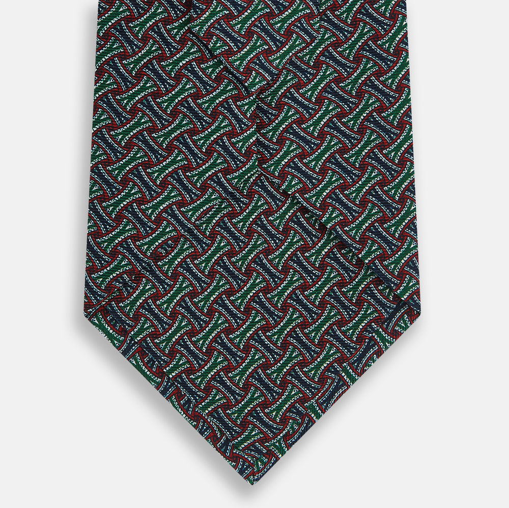 The Forest Green and Red Weave-Patterned Printed Silk Tie by Turnbull & Asser features an intricate geometric motif in red, green, blue, and white, crafted from luxurious English silk for classic sophistication.