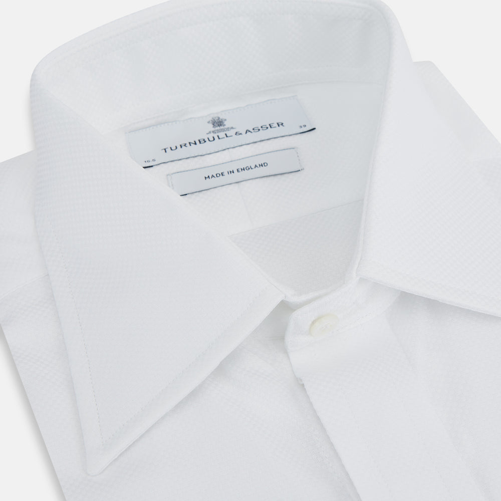 The Turnbull & Asser Casino Royale White Dress Shirt, as seen on James Bond, features a classic Bond collar, button-down front, and buttoned cuffs, shown on a white background.