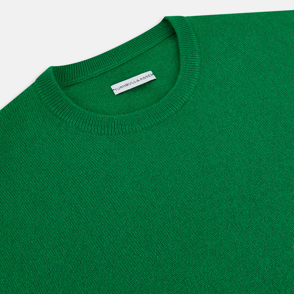The Turnbull & Asser Grass Green Cashmere Round Neck Jumper features long sleeves, ribbed cuffs, collar, and hem, shown on a white background.