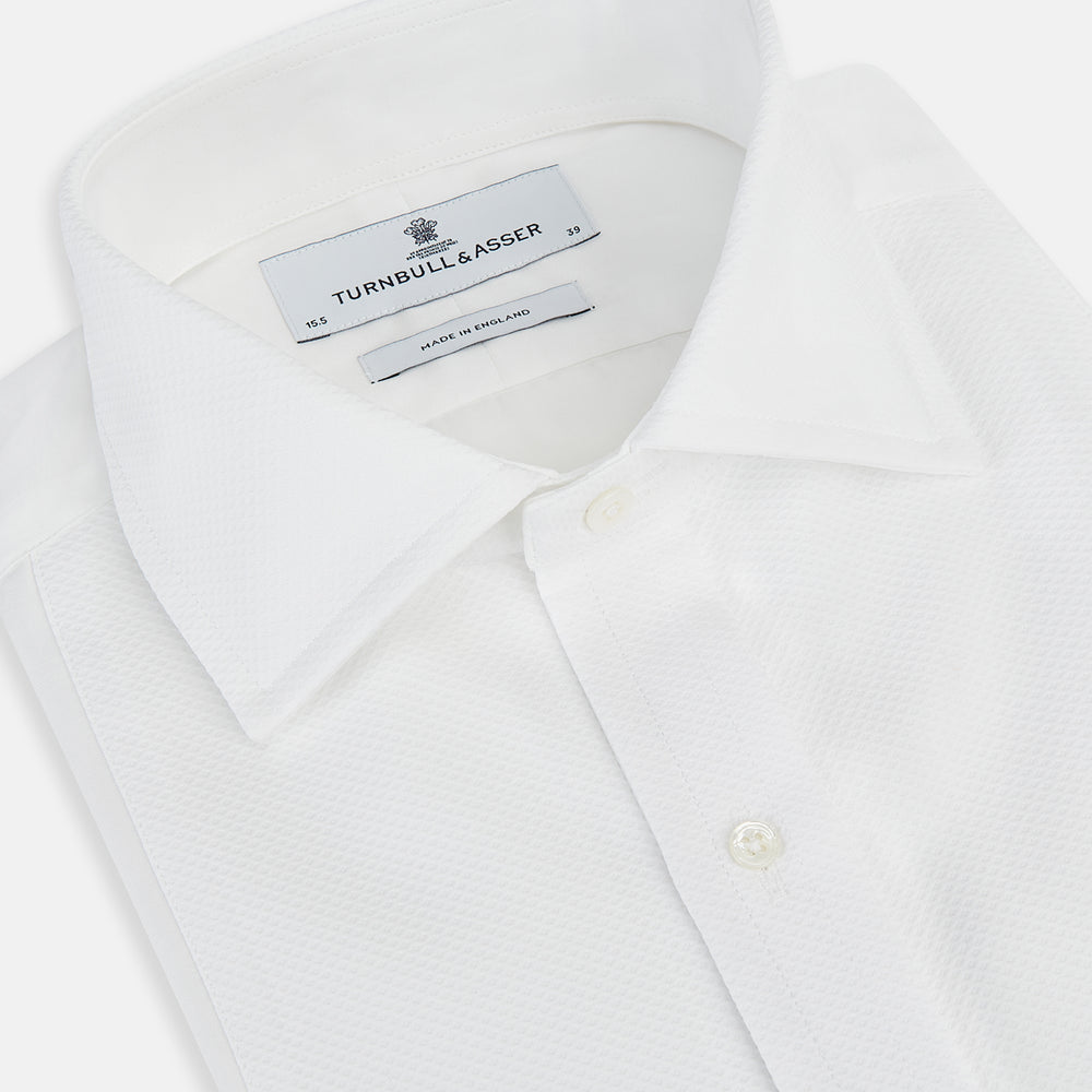 The Turnbull & Asser Tailored Fit White Marcella Front Shirt features a Kent Collar and double cuffs, shown laid flat on a white background. Perfect as a black tie shirt for formal events.