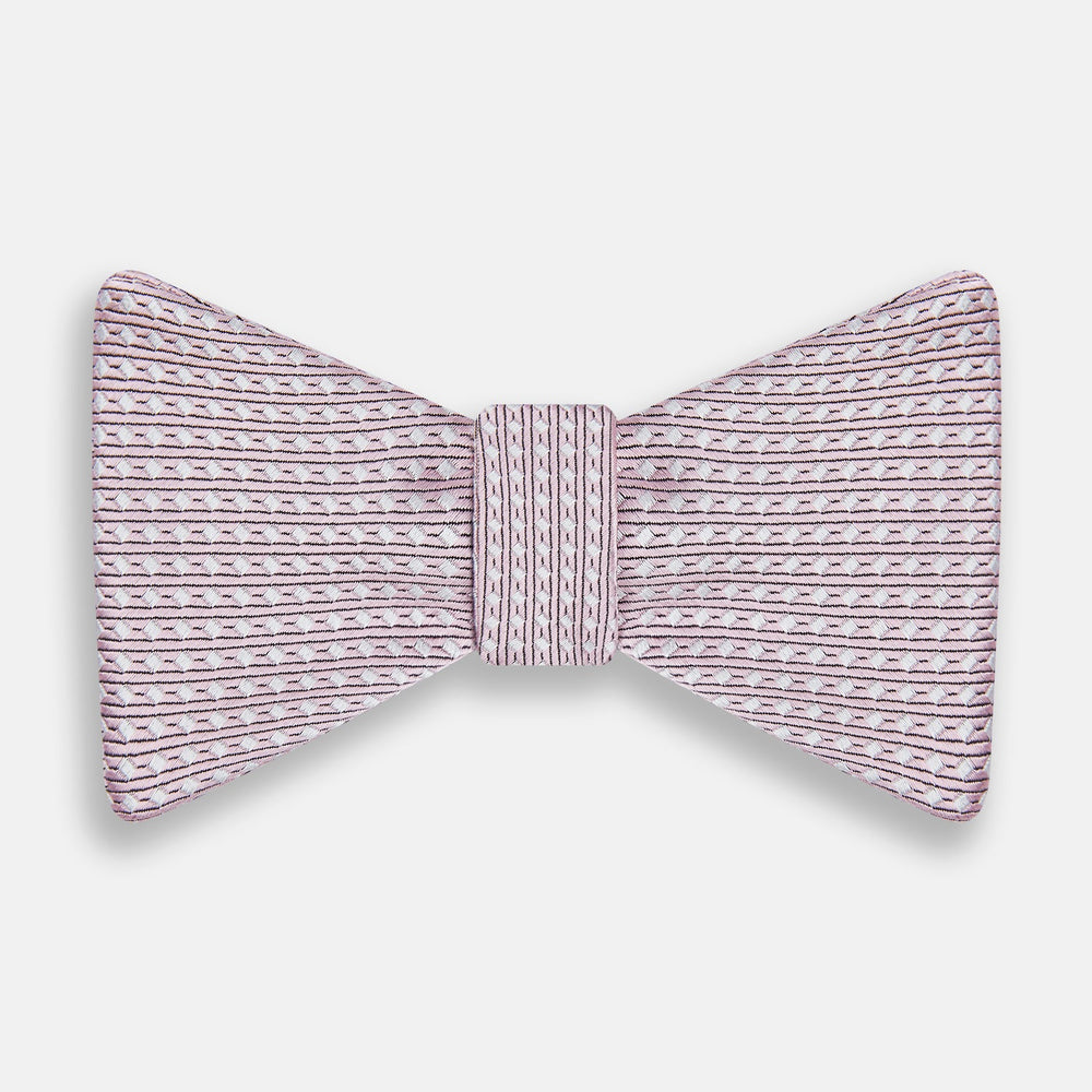 The Turnbull & Asser Pale Pink and White Square Silk Bow Tie features white stripes and subtle square patterns, ideal for formalwear. Shown on a white background.