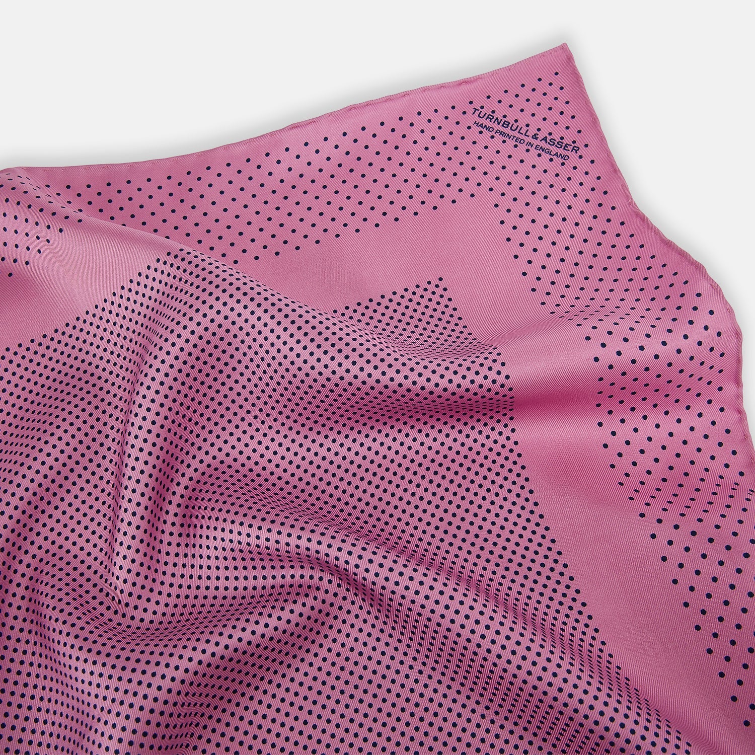 View 2 of product The Pink Dot Silk Pocket Square by Turnbull & Asser features pink silk with a border of small black dots, expertly handcrafted for a stylish touch to any suit. Fold to showcase both sides for added elegance.
