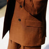 View 4 of product The Turnbull & Asser Rust Linen-Wool-Silk Bertie Blazer is a red double-breasted jacket with peak lapels, black buttons, and flap pockets, tailored in Italy from a luxury linen-wool-silk blend and shown on a white background.