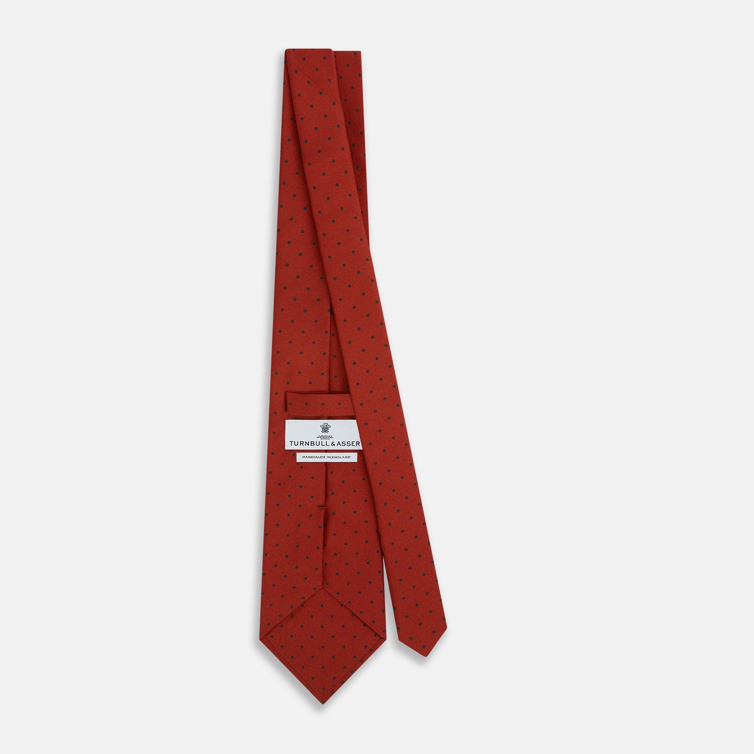 View 4 of product The Turnbull & Asser Red and Navy Polka Dot Silk Tie is elegantly rolled on a white background, highlighting classic British craftsmanship.