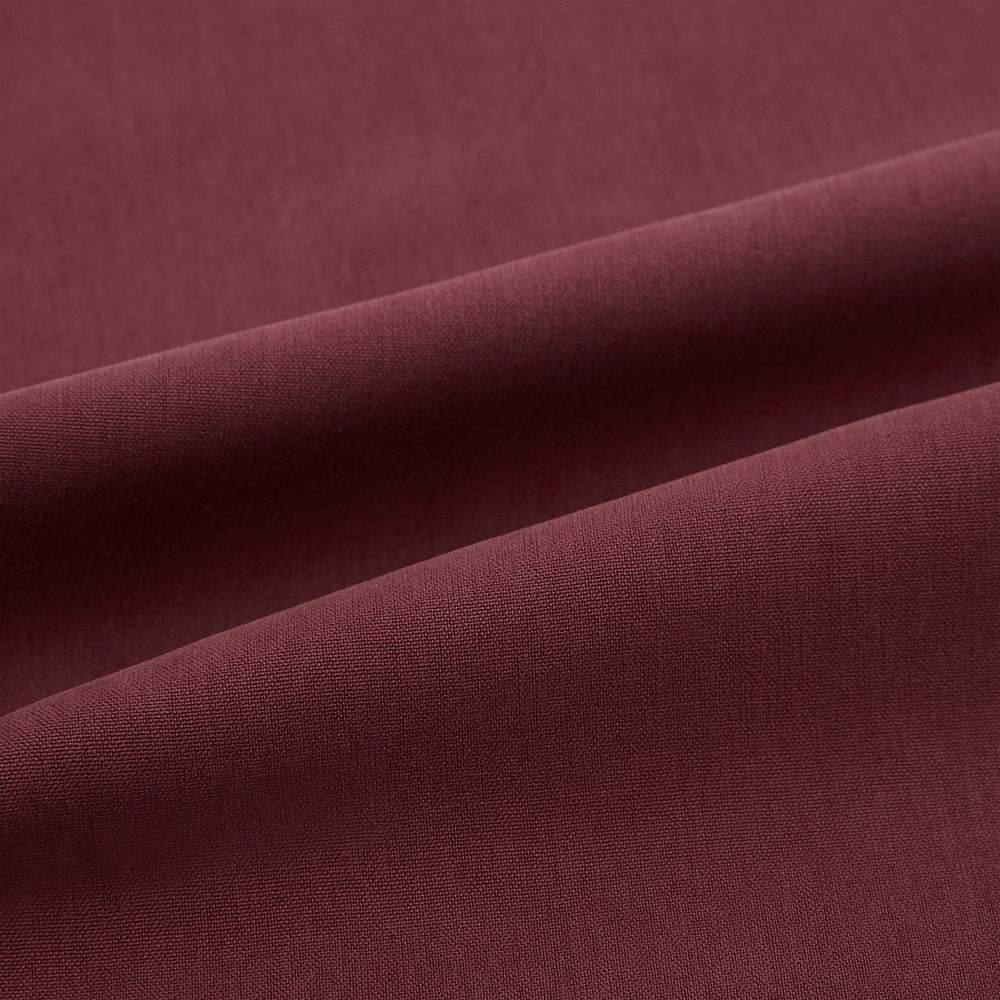 The Turnbull & Asser Burgundy Silk Pyjama Set features a long-sleeve, button-up shirt with chest pocket and matching pants with elastic waistband and side pocket, shown on a white background.