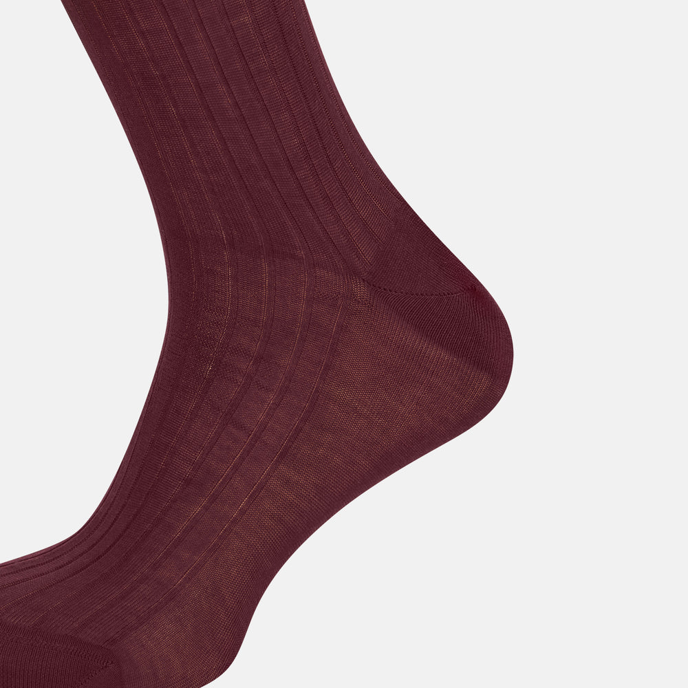 A single Burgundy Long Sock by Turnbull & Asser is shown on a white background, angled to display its over-the-calf length, fitted shape, and ribbed texture along the calf and foot.