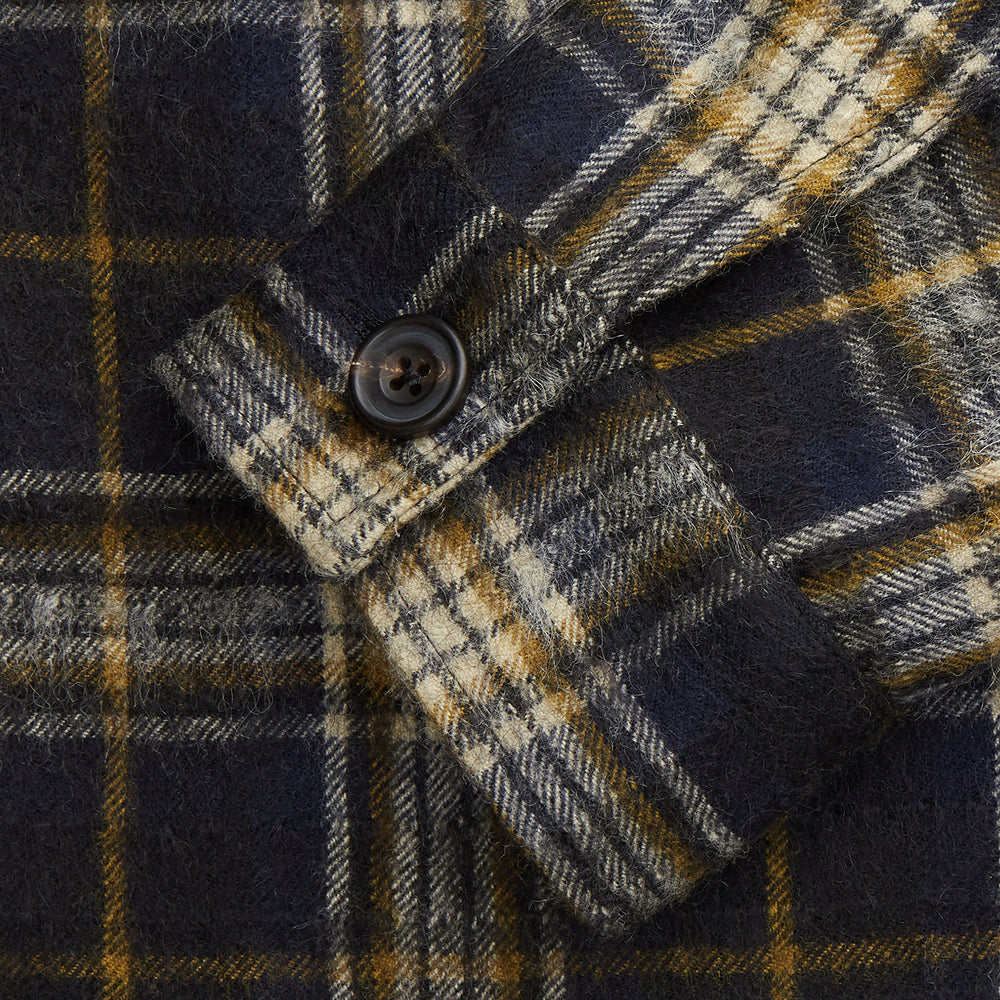 The Turnbull & Asser Navy and Beige Check Wool and Mohair Blend Somerset Overshirt, featuring long sleeves, two chest pockets, and a classic collar, is laid flat on a white background.