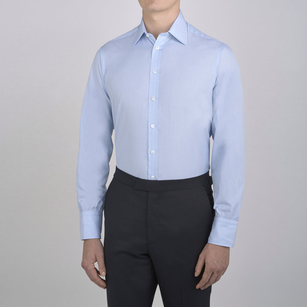 The Turnbull & Asser Light Blue End-on-End Shirt features a T&A collar and 3-button cuffs, neatly displayed against a plain white background—ideal for pairing with a navy suit.