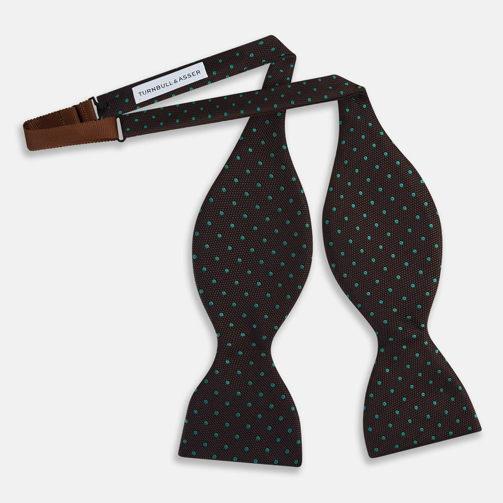 The Blue and Brown Micro Dot Silk Bow Tie by Turnbull & Asser features subtle blue micro dots on brown silk, photographed on a plain white background—a sophisticated men's accessory perfect for formal events.