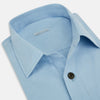 View 2 of product The Blue Hyde Overshirt by Turnbull & Asser features a light blue hue, long sleeves, a button-up front, and a single chest pocket. Crafted from sanforised cotton and shown laid flat on a white background.