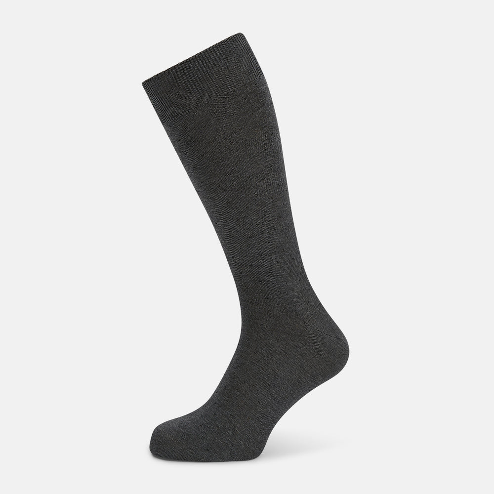 The image shows a single Turnbull & Asser Dark Steel/Navy Polka Dot Mid-Length Sock standing upright on a plain white background, featuring a ribbed cuff and a smooth, seamless finish.