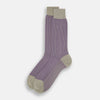View 2 of product The Turnbull & Asser Concrete Houndstooth Mid-Length Sock features a purple and black houndstooth pattern with beige cuff, heel, and toe, crafted from soft cotton and shown on a plain white background.