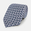 View 1 of product The Turnbull & Asser Navy and Pink Weave-Patterned Printed Silk Tie is shown rolled up on a white background, featuring a stylish geometric design.