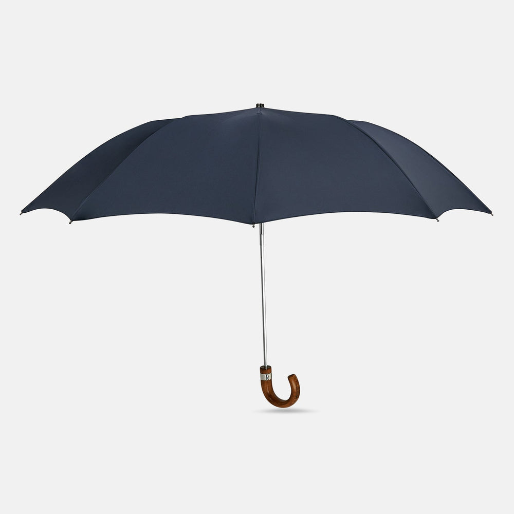 The Turnbull & Asser Navy Telescopic Umbrella features a brown maple crook handle and is shown fully open against a plain white background.