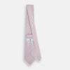 View 4 of product The Turnbull & Asser Lilac Flower-Patterned Printed Silk Tie, featuring a light lilac hue and small white circular designs, is shown rolled up against a plain white background.