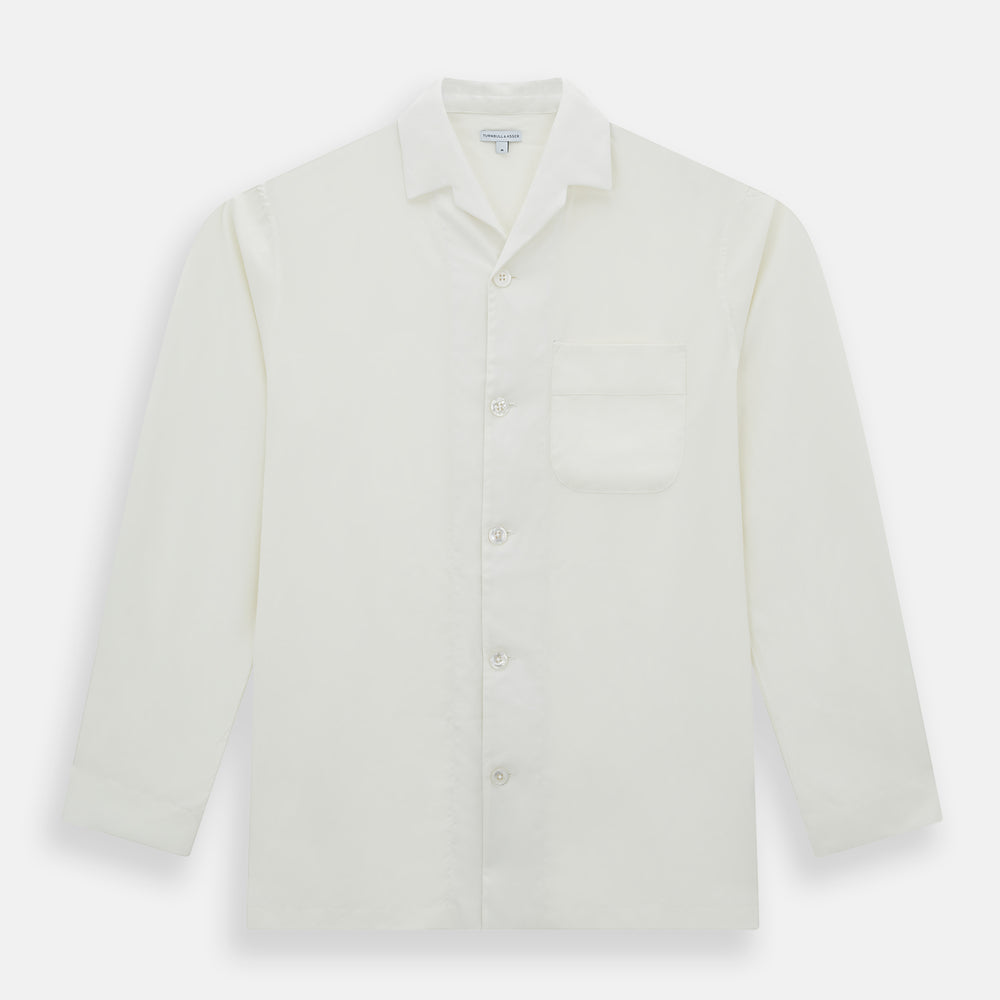 The Turnbull & Asser Cream Silk Pyjama Set, shown laid flat on a white background, features a long-sleeve button-up top with a chest pocket and matching pants with an elastic drawstring waist—ideal for comfortable loungewear.