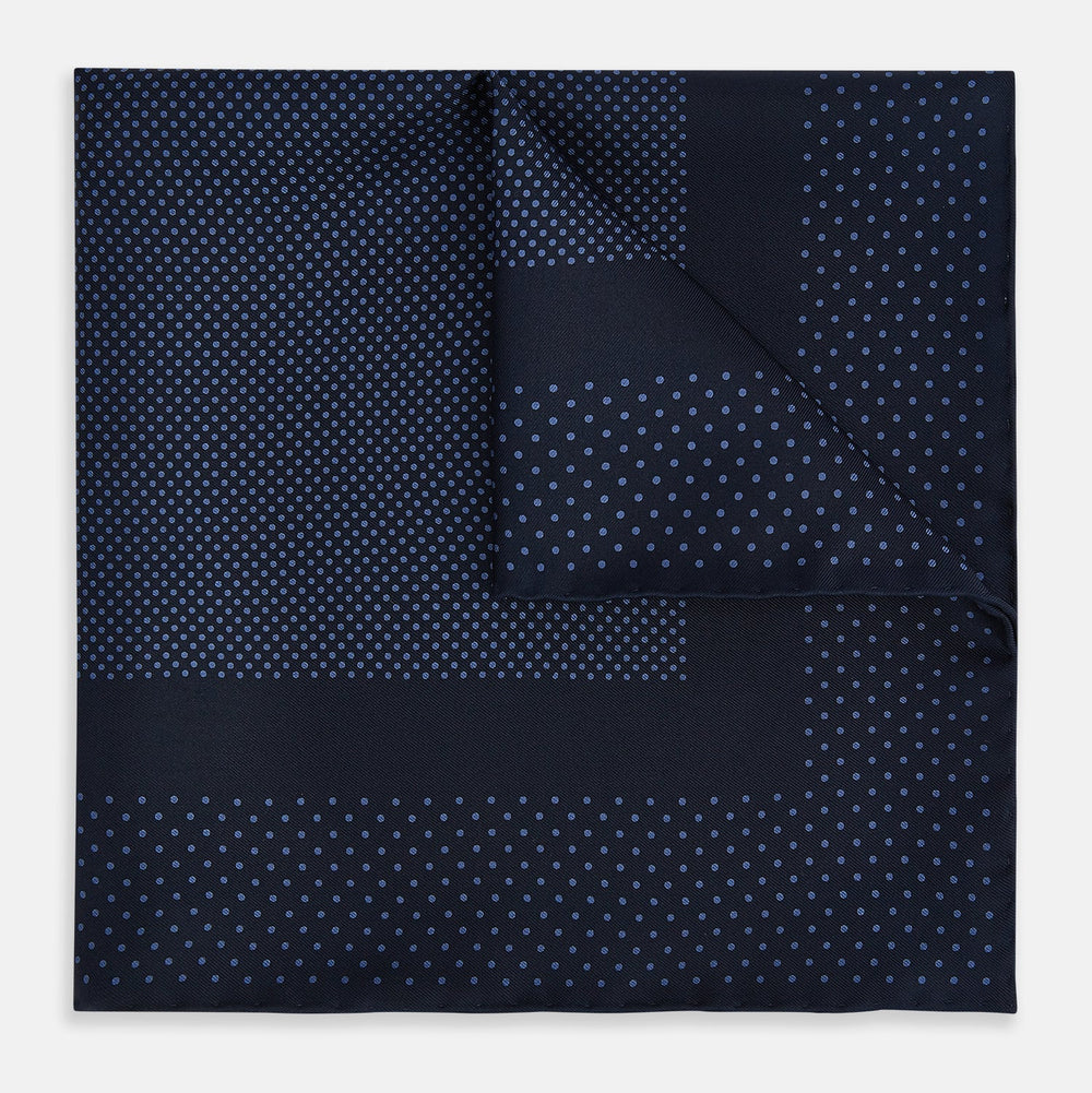 The Turnbull & Asser Midnight Blue Dot Silk Pocket Square features a neatly folded, handmade design with small light blue polka dots and a plain border.