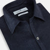 View 2 of product The Navy Linen Windsor Shirt by Turnbull & Asser features long sleeves, white buttons, a Turnbull collar, and buttoned cuffs in dark navy blue linen. Shown laid flat on a white background.