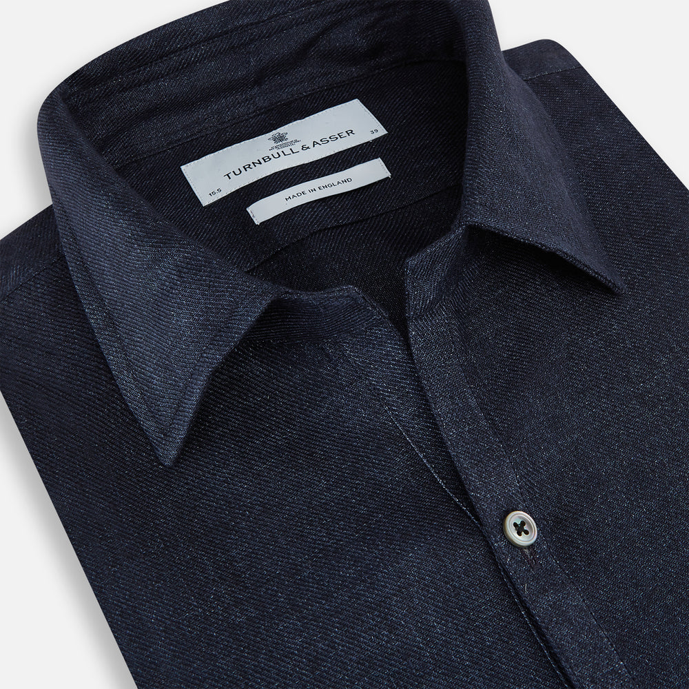 The Navy Linen Windsor Shirt by Turnbull & Asser features long sleeves, white buttons, a Turnbull collar, and buttoned cuffs in dark navy blue linen. Shown laid flat on a white background.