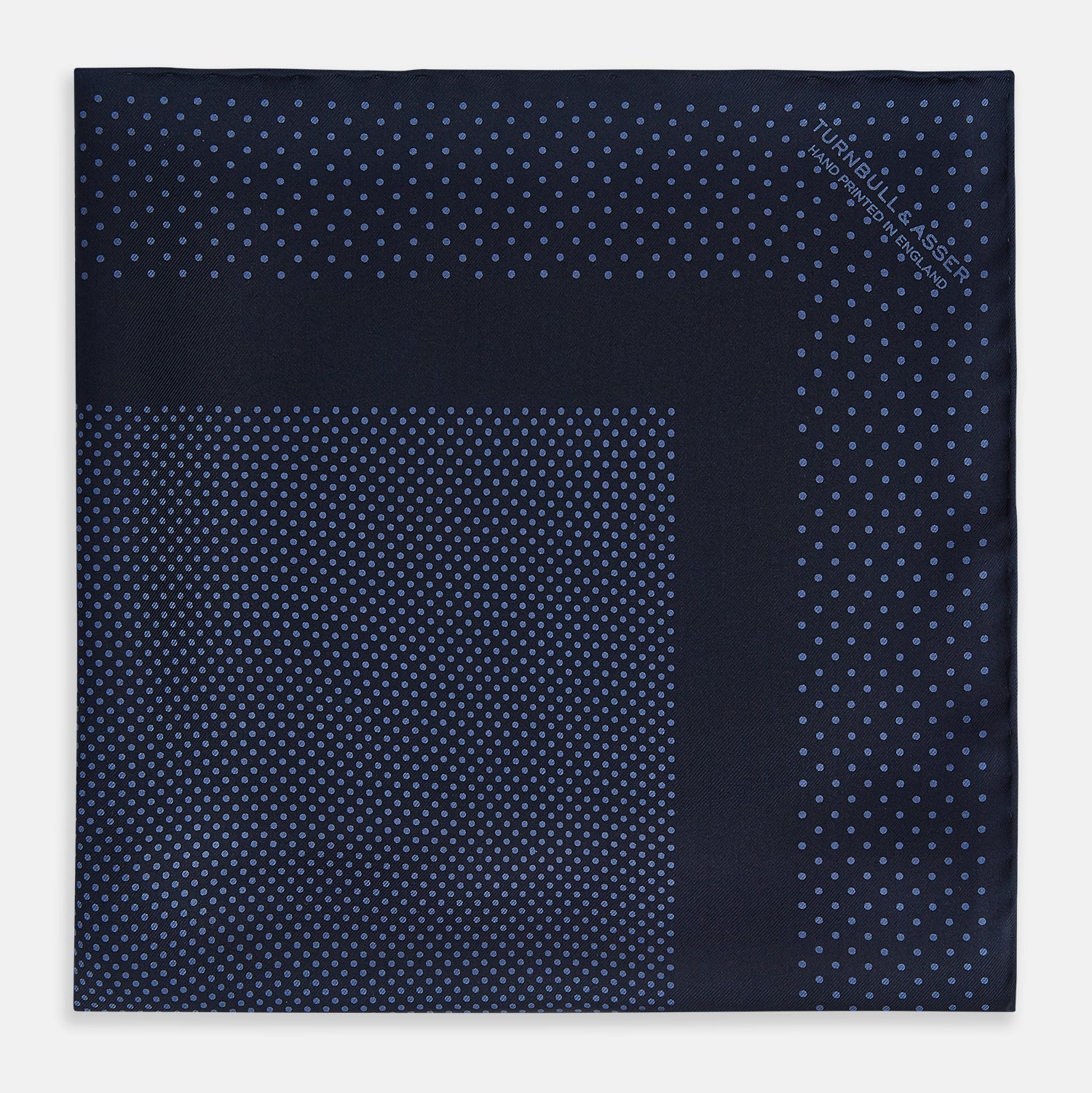 View 3 of product The Turnbull & Asser Midnight Blue Dot Silk Pocket Square features a neatly folded, handmade design with small light blue polka dots and a plain border.