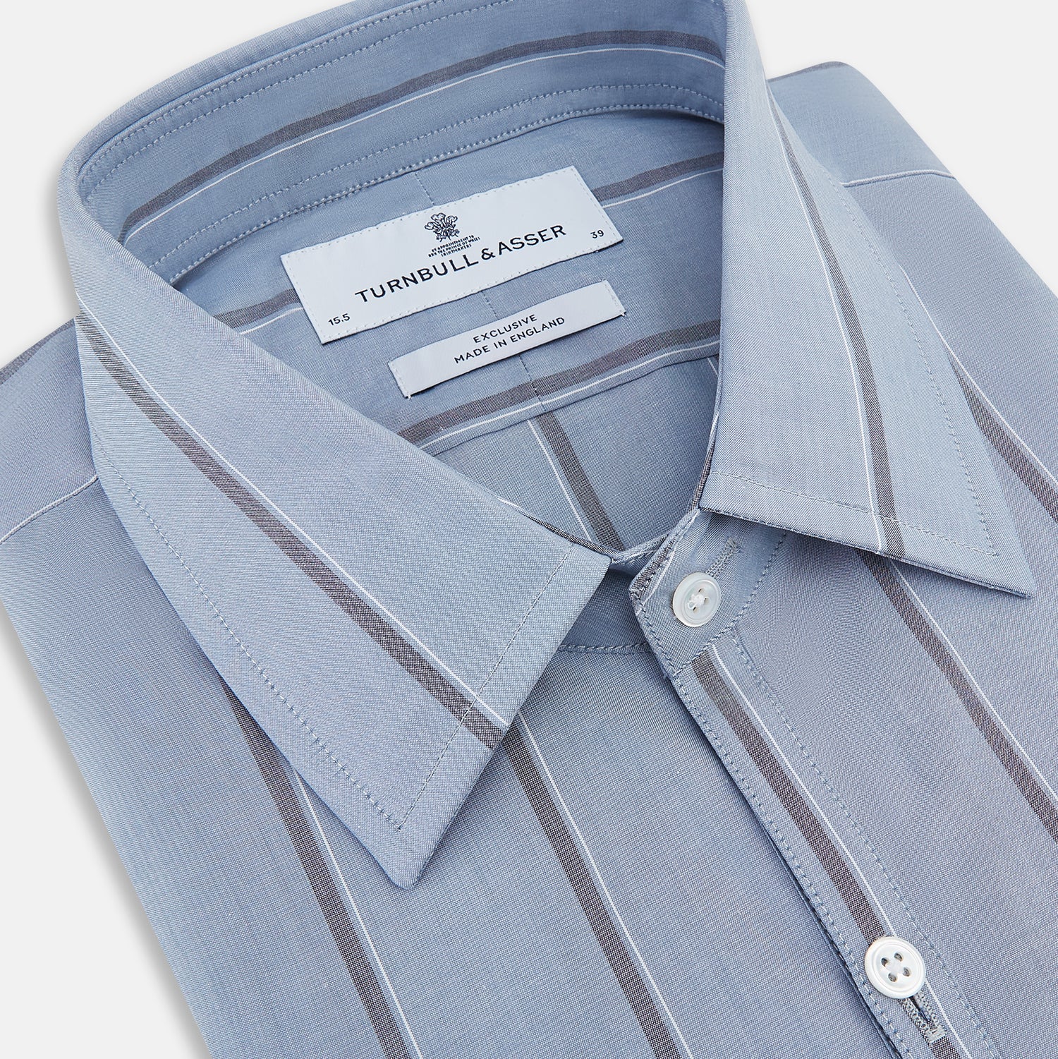 View 2 of product The Steel Blue Track Stripe Westminster Shirt by Turnbull & Asser features dark pinstripes, a classic collar, white buttons, and buttoned cuffs—expertly crafted to highlight British craftsmanship. Laid flat on white background.