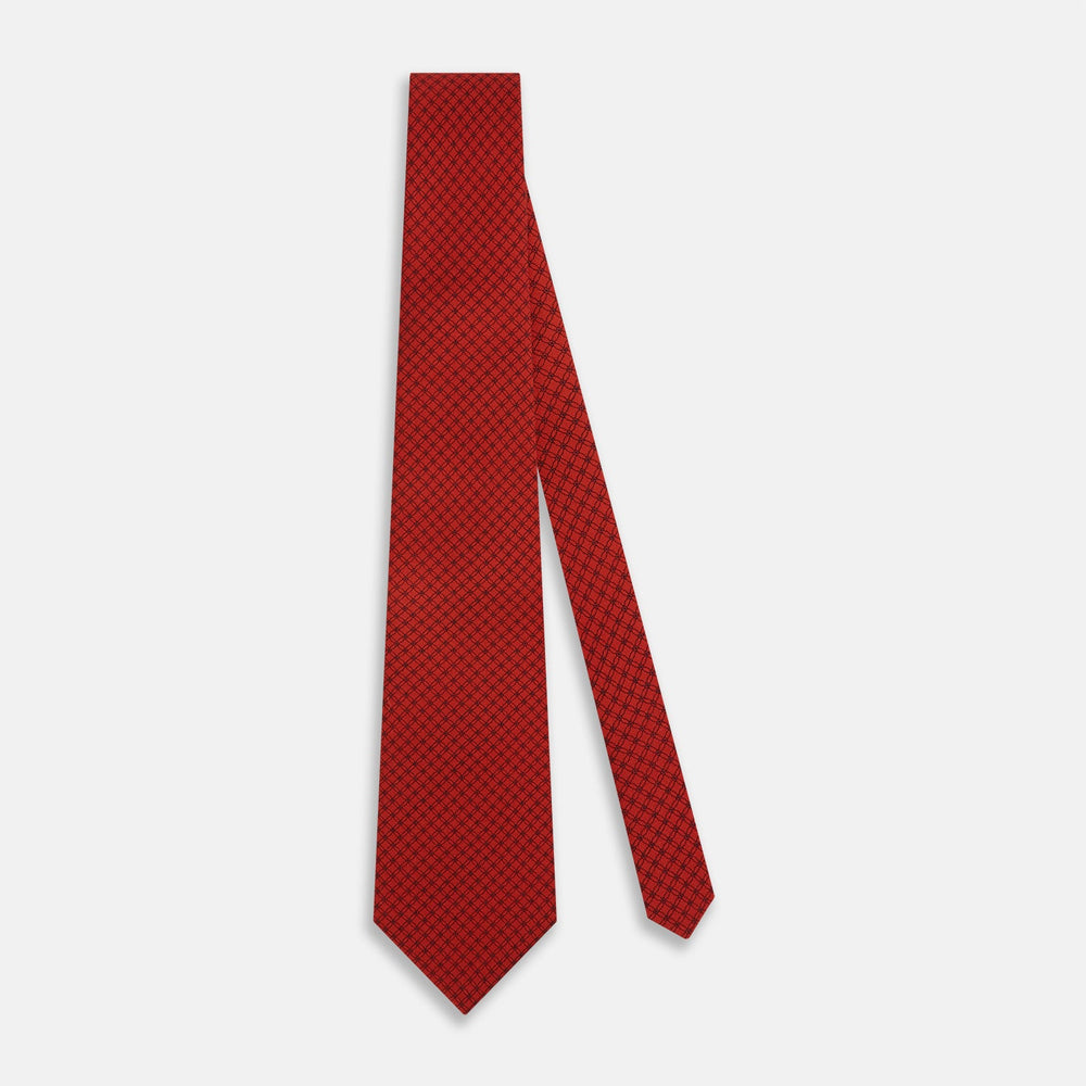 The Turnbull & Asser Red Lattice-Patterned Printed Silk Tie, crafted from fine English silk, is shown rolled up on a plain white background.