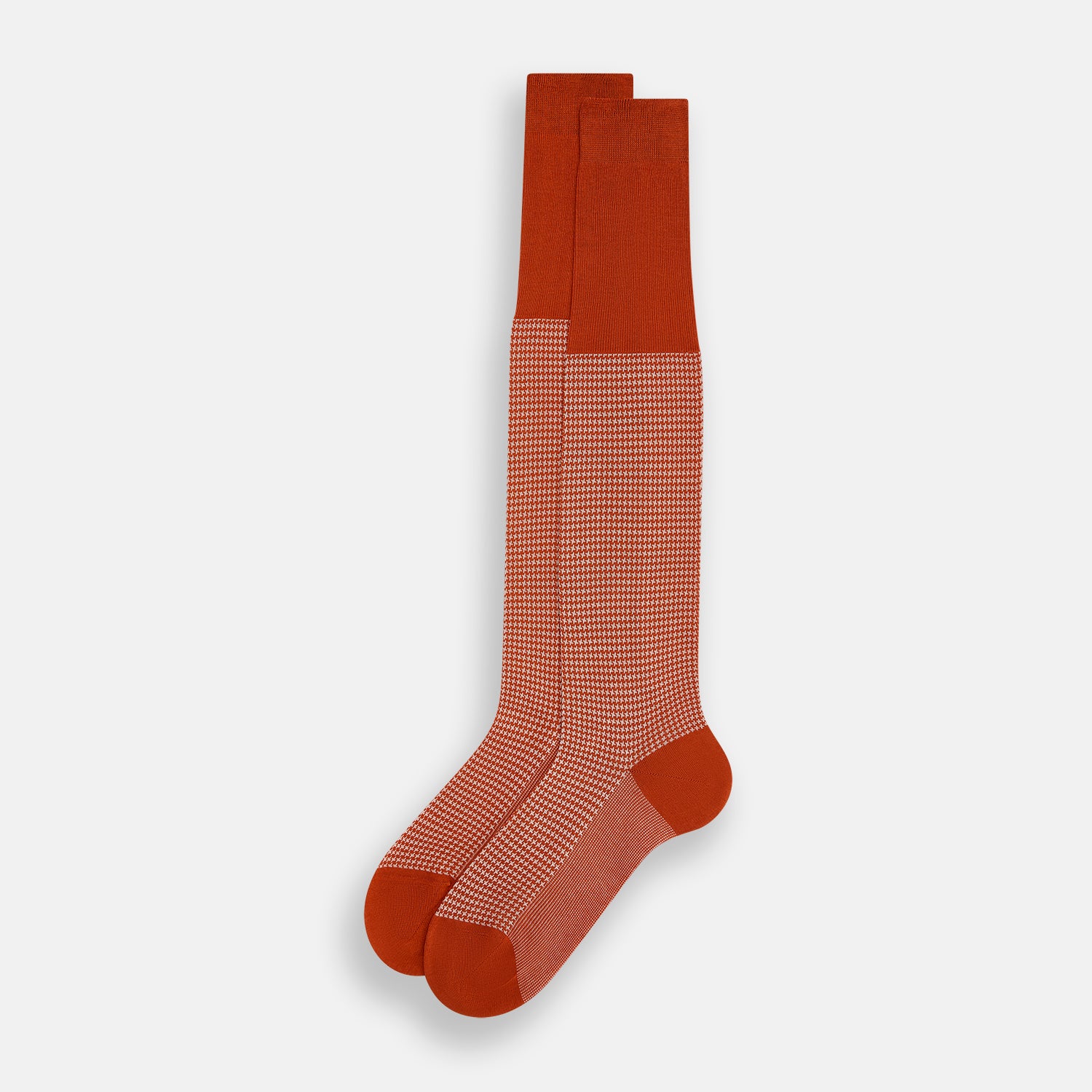 View 2 of product The Turnbull & Asser SOCKS LONG COTTON HOUNDSTOOTH ROSE is a single over-the-calf sock in rusty orange with a white houndstooth pattern and solid orange toe, heel, and cuff, shown on a plain white background.
