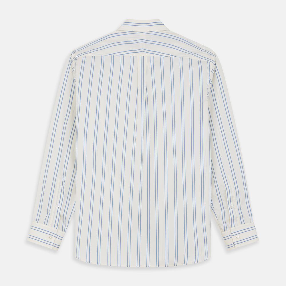 A man with short brown hair stands against a beige background in a Turnbull & Asser Blue and Off-White Stripe Cotton Weekend Fit Finch Shirt, featuring vertical stripes and a Derby collar, paired with dark pants. One hand is in his pocket; he has a neutral expression.