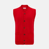 View 1 of product The Turnbull & Asser Red Merino V-Neck Sleeveless Cardigan features a ribbed collar, button front, and two front pockets—a refined lightweight layer—shown against a plain white background.