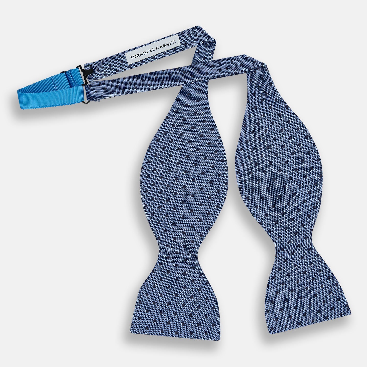 View 2 of product The Turnbull & Asser Blue Micro Dot Silk Bow Tie features a subtle textured pattern with small navy polka dots, shown on a white background—an ideal accessory for smart attire.