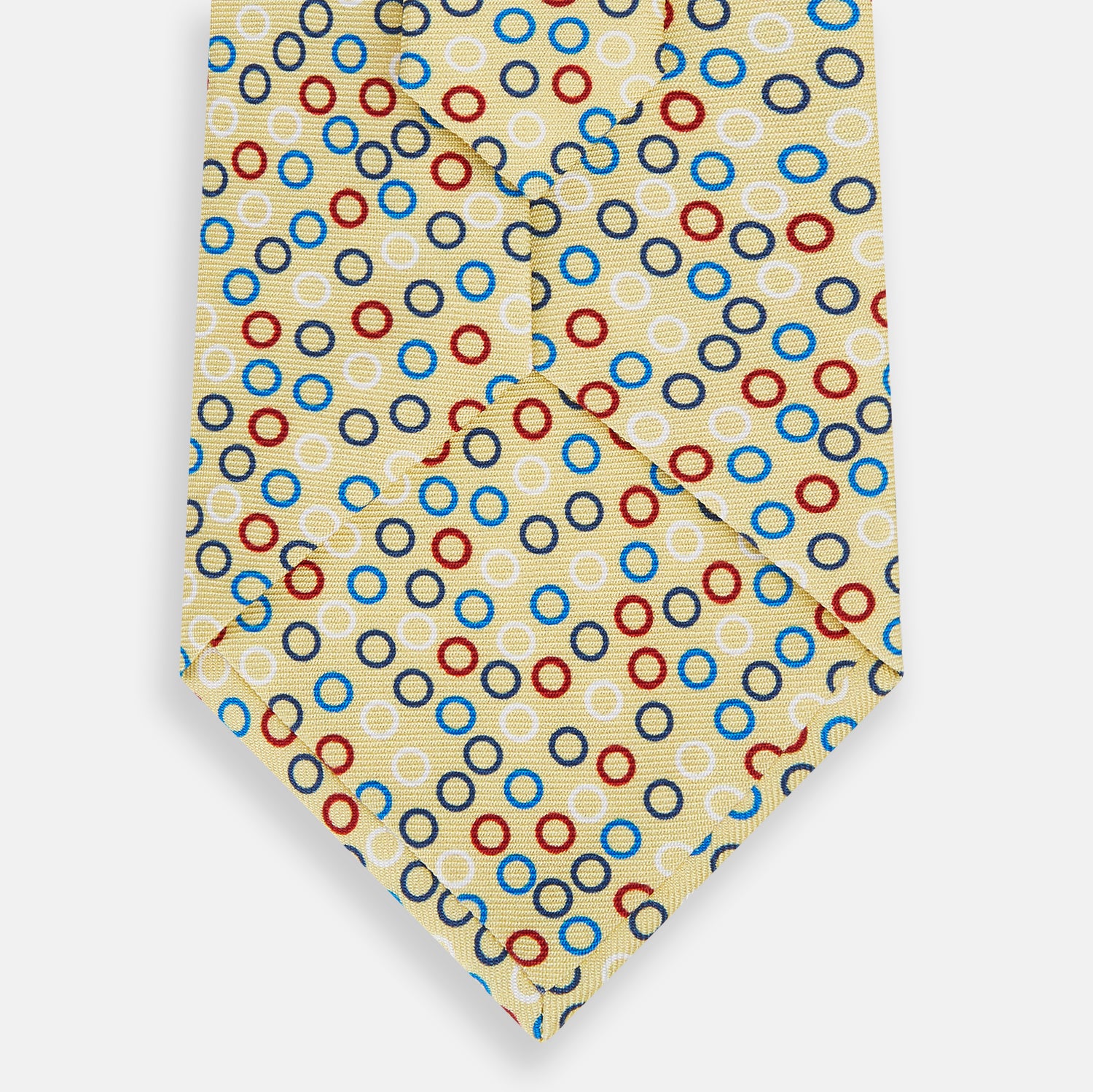 View 3 of product The Turnbull & Asser Multi-coloured Circle Yellow Printed Silk Tie features vibrant blue, red, and black circles evenly spaced across luxurious English silk.
