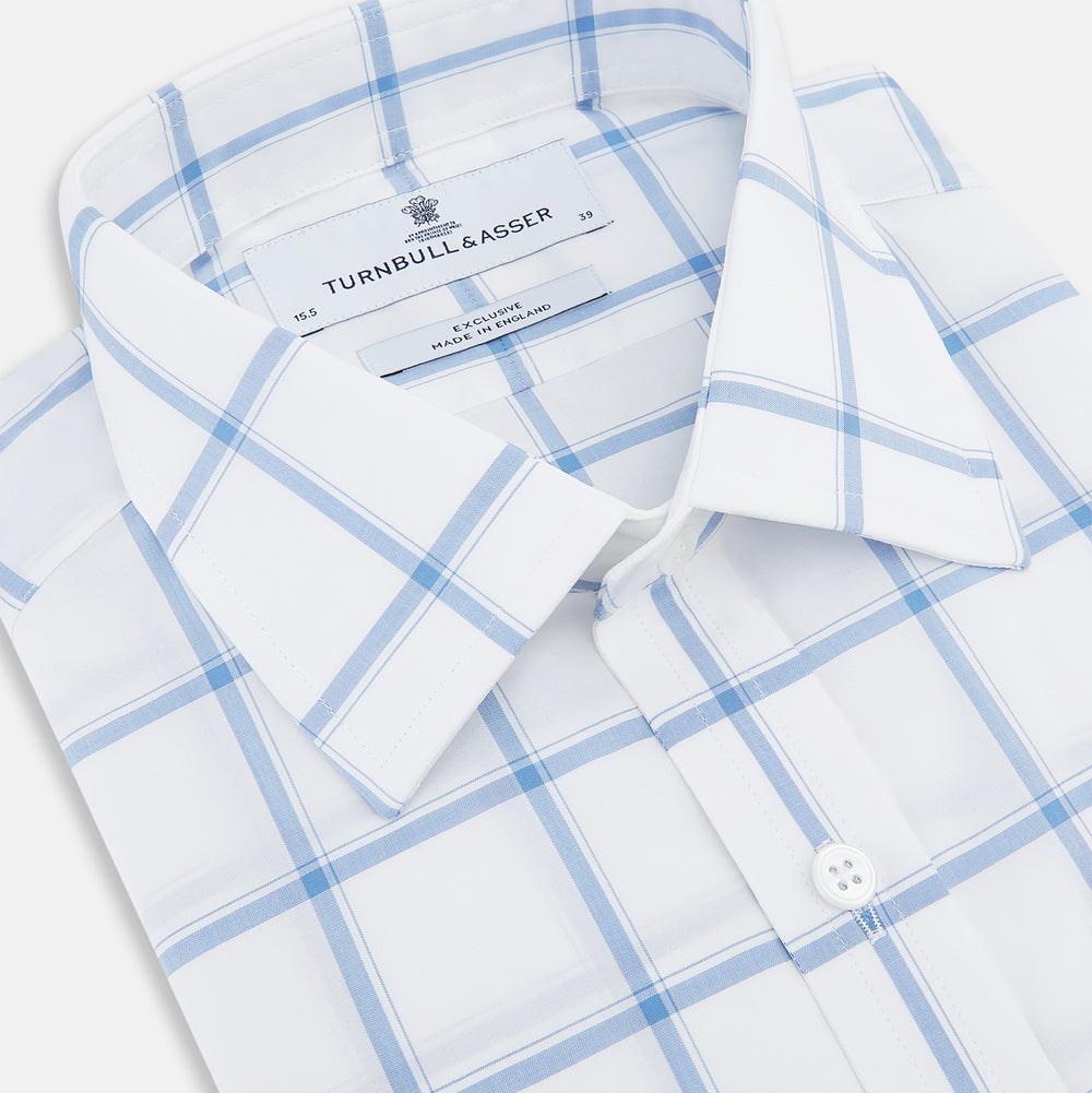 The Turnbull & Asser Colony Blue Grid Check Mayfair Shirt features long sleeves, a button-down front, Italian cotton fabric, a spread collar, and buttoned cuffs, shown against a plain white background.