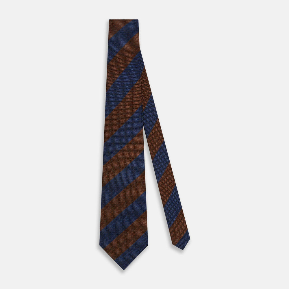 A close-up of the Turnbull & Asser Brown and Navy Block Stripe Silk Tie displays its textured pattern with classic suiting diagonal stripes in navy blue and brown on a light background.