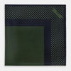 View 3 of product The Turnbull & Asser Navy and Kelly Green Dot Silk Pocket Square features small green dots on navy silk and a folded corner displaying the reverse—an elegant, handmade accessory perfect for enhancing any formal attire.
