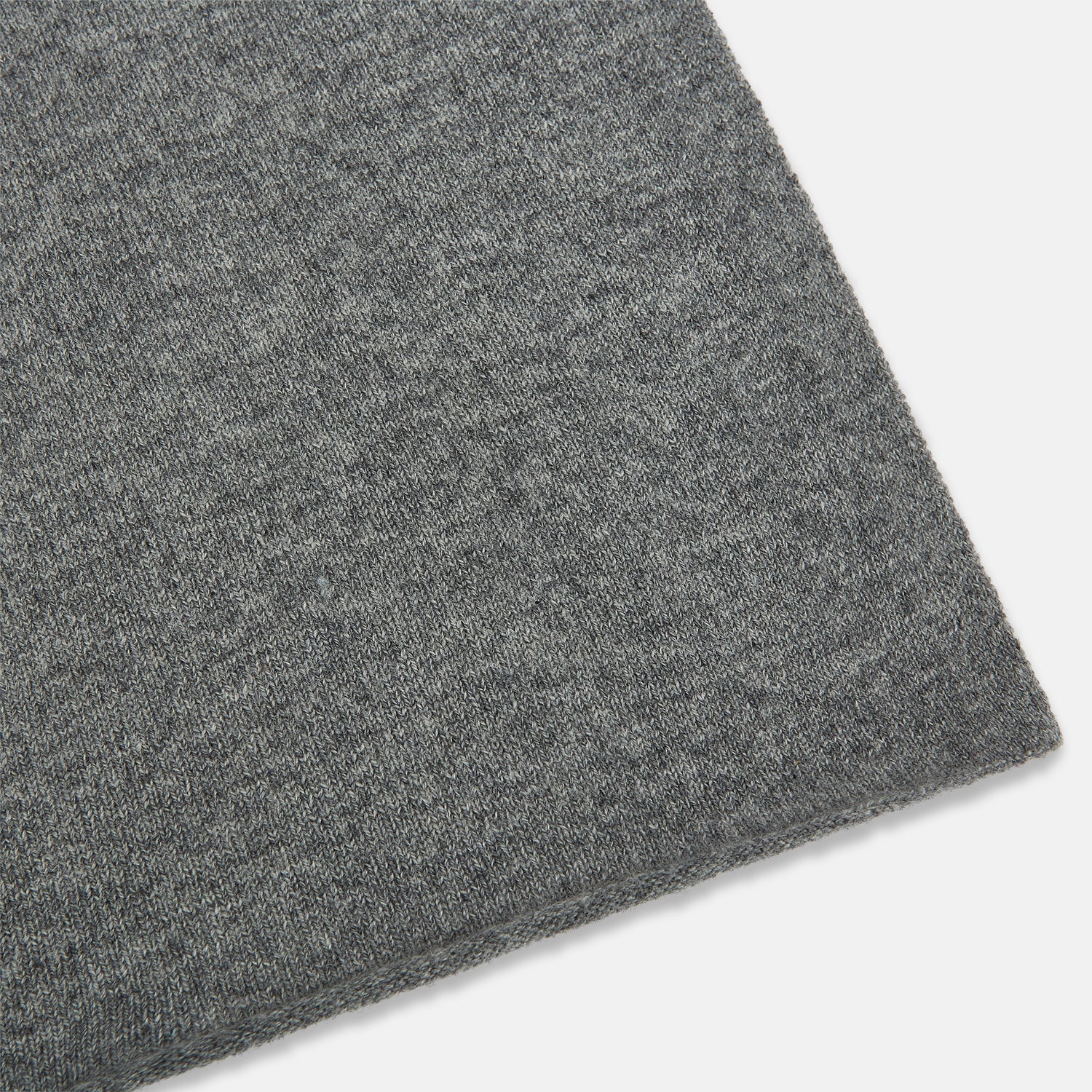 Image 2 of product The Turnbull & Asser Plain Grey Cashmere Knitted Scarf is shown draped against a white background, highlighting its soft luxury and timeless appeal.