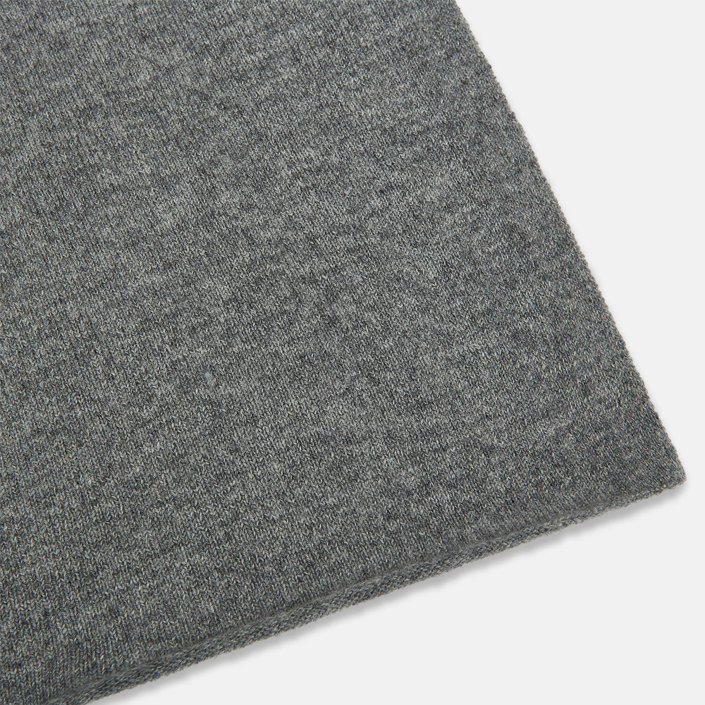 The Turnbull & Asser Plain Grey Cashmere Knitted Scarf is shown draped against a white background, highlighting its soft luxury and timeless appeal.