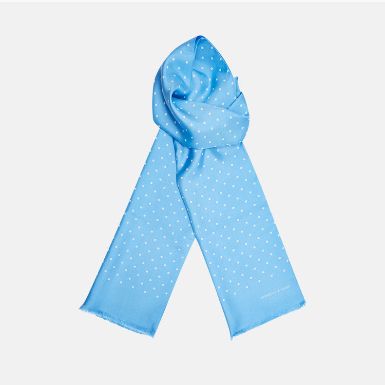 The Turnbull & Asser Azure and White Spotted Silk Scarf features small white polka dots, subtle fringe at the ends, and a delicate hand-printed design, displayed on a plain white background.