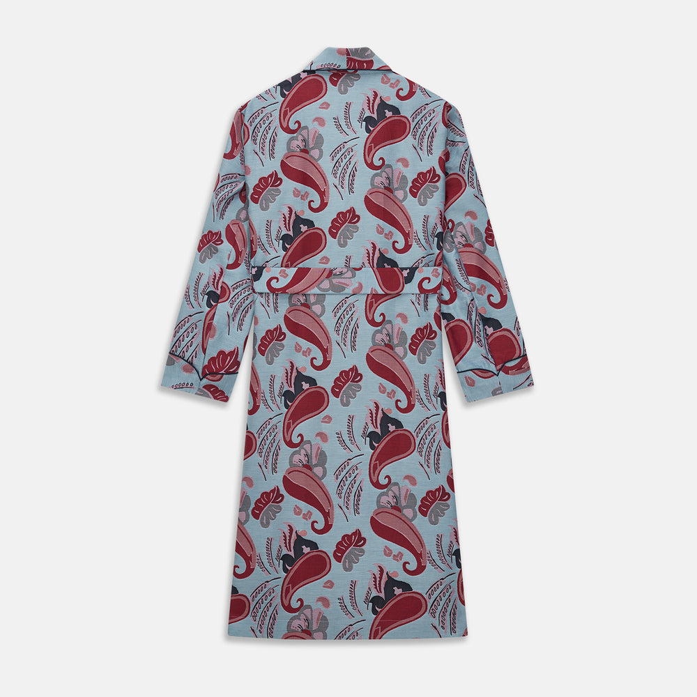 The Blue Paisley Pattern Cotton Arnold Gown by Turnbull & Asser features light blue jacquard cotton with a red and black paisley design, long sleeves, a matching belt, and two front pockets for a subtle Bloomsbury-inspired look.