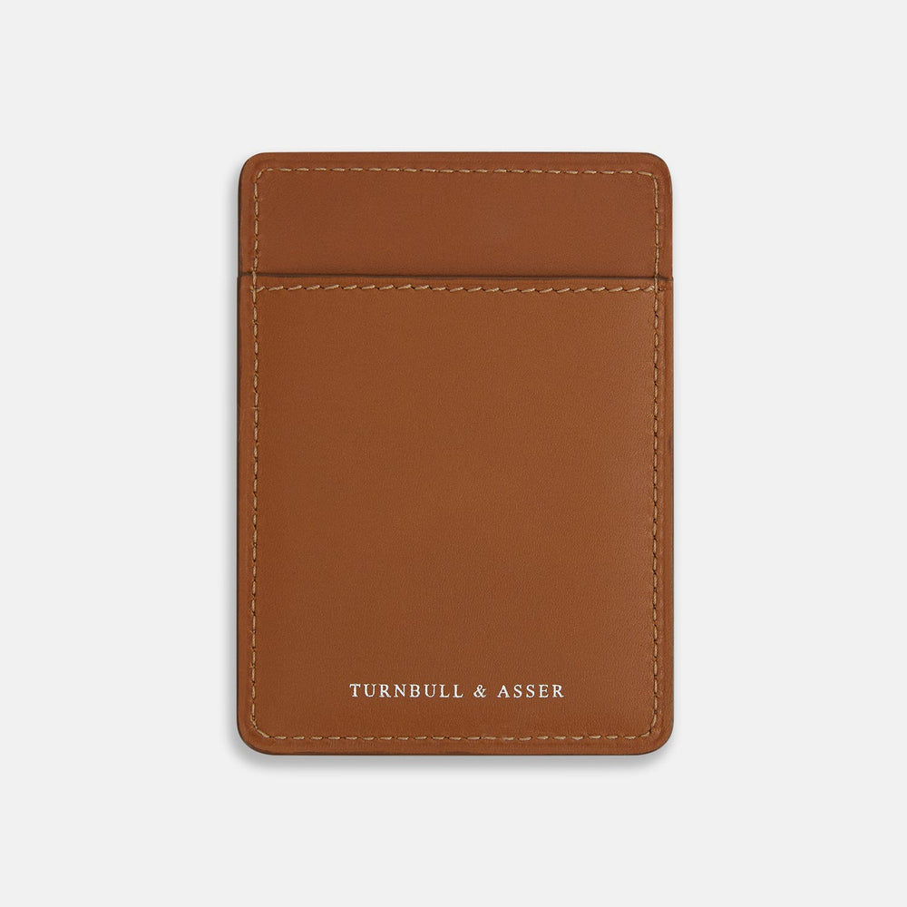 The Camel Two-slot Card Case by Turnbull & Asser is crafted from Italian leather with white stitching, featuring a front pocket and the brand’s logo embossed in white—a sleek accessory for everyday use.