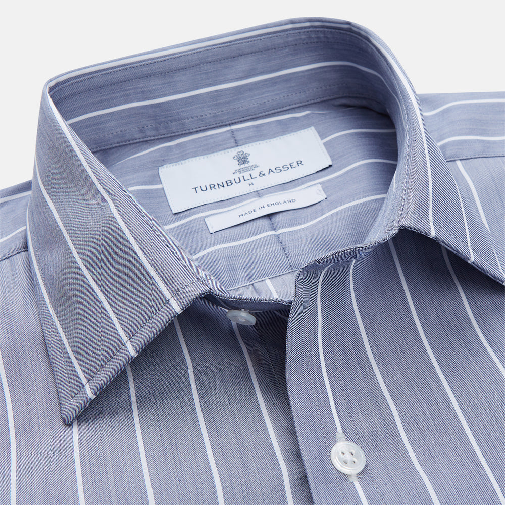 The Turnbull & Asser Pale Blue and White Pinstripe Cotton Blend Weekend Fit Finch Shirt features long sleeves, a chest pocket, and white buttons—ideal for classic, casual style. Shown laid flat on a white background.